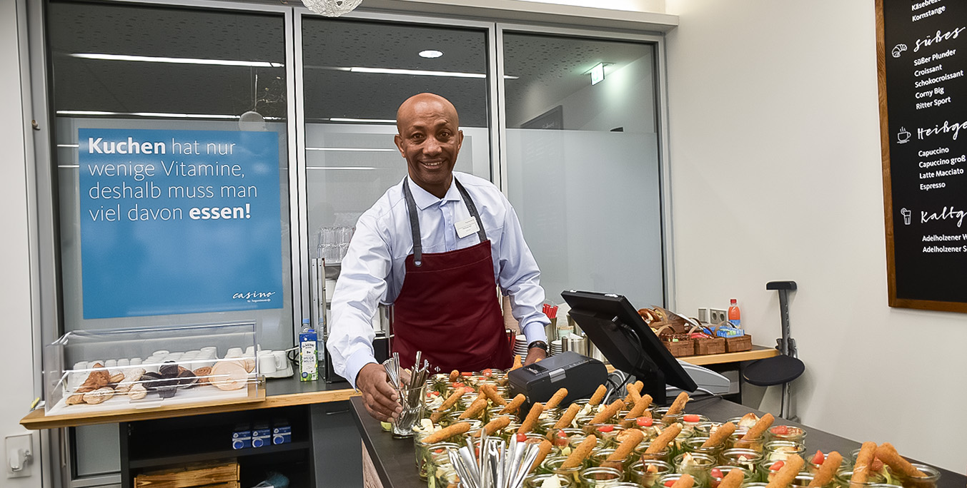 Ein Mitarbeiter der Augustinum Gastronomie stellt Gerichte für ein Catering zusammen
