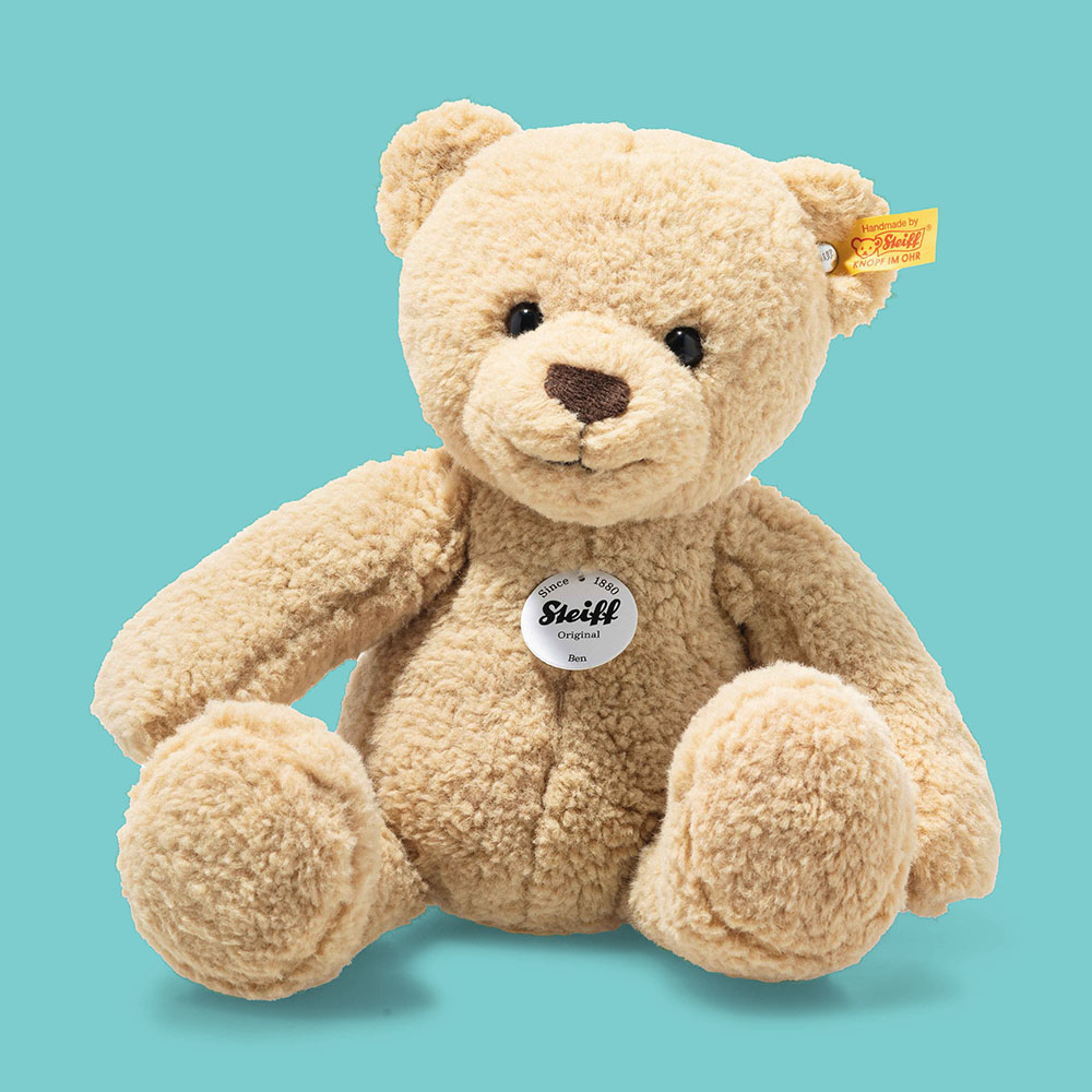 ein Steiff-Teddy vor petrolfarbenenem Hintergrund