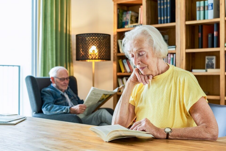 Ein Seniorenpaar liest in einer Wohnung des Augustinum Berchtesgadener Land 