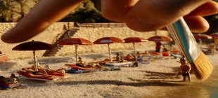 Strandszene mit Schirmen in Liegen, große Hand mit Pinsel