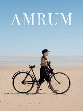 Junge schiebt Fahrrad am Strand