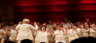 Chor singend und mit Fingern schnipsend auf Bühne stehend