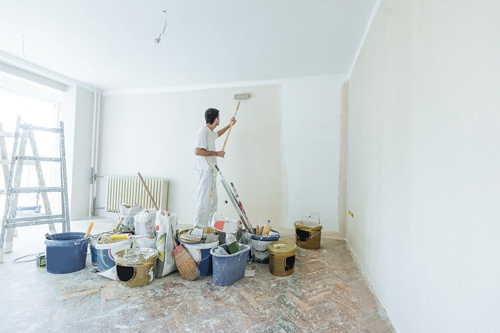 Ein Maler streich eine Wand weiß