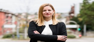 Eine blonde Frau steht mitten in einer Straße