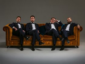Vier Sänger des Ensembles Ringmasters auf einem Sofa