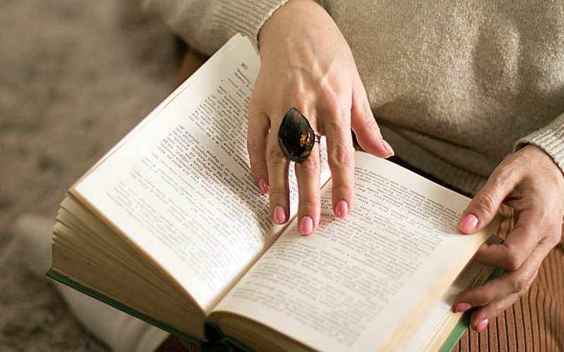 Detailansicht: Hand berührt aufgeschlagenes Buch