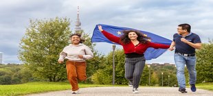drei laufende junge Leute im Hintergrund der Florianturm
