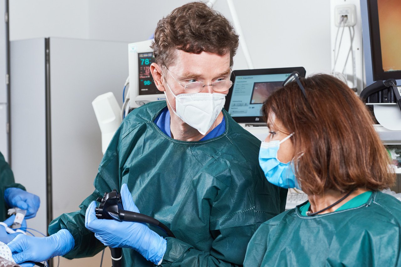 Ein Arzt und eine Pflegerin im Dialog während eines endoskopischen Eingriffs