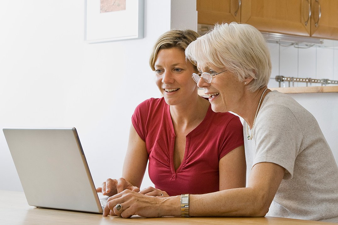 zwei Frauen schauen auf den Bildschirm eines Laptops