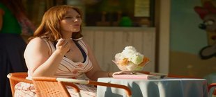 Frau isst großen Eisbecher