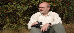 Dr. Uwe Westphal mit Fernglas am Wald