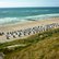 Blick auf einen Strand mit Strandkörben und Dünenausläufern