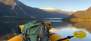 Aufblasbares Boot auf einem Fluss & ausgeblichener Rinderschädel in der Pampa