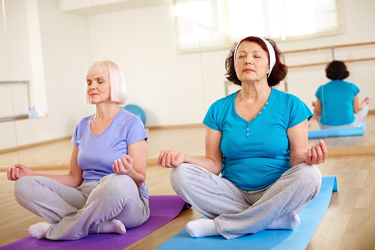 Zwei Frauen im Schneidersitz beim Yoga