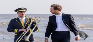 Filmszene mit zwei Musikern am Strand