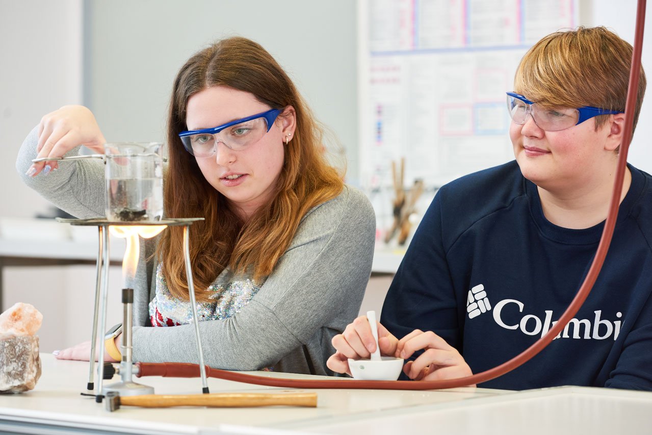 Zwei Schüler*innen der Samuel-Heinicke-Realschule machen ein Experiment mit Bunsenbrenner im Chemieunterricht