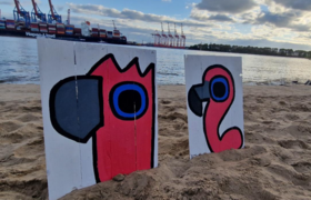 Gemalte Bilder im Elbsand vor Hafenkränen