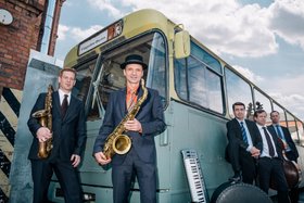 5 Musiker vor einem historischen Bus