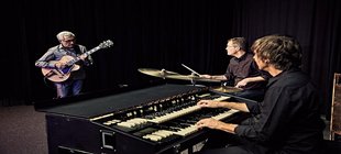 drei Musizierende mit Gitarre, Schlagzeug und Hammond-Orgel