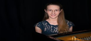 Junge Frau sitzt am Flügel