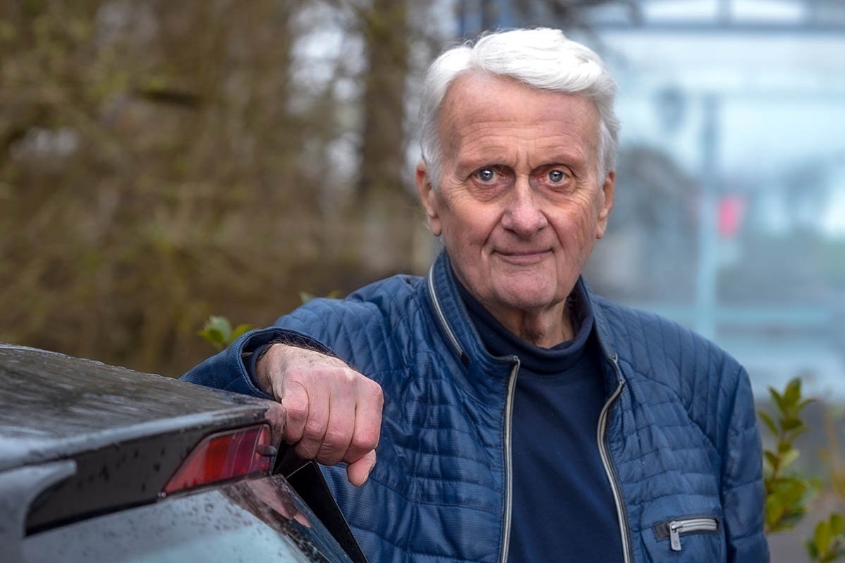 Ernst Roeckl lehnt an seinem Auto und schaut in die Kamera