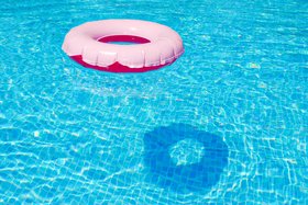 rosafarbener Schwimmring in leuchtend blauem Wasser