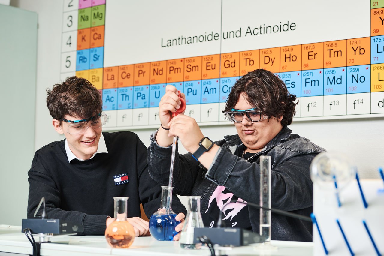 Zwei Schüler machen ein Experiment im Chemieunterricht