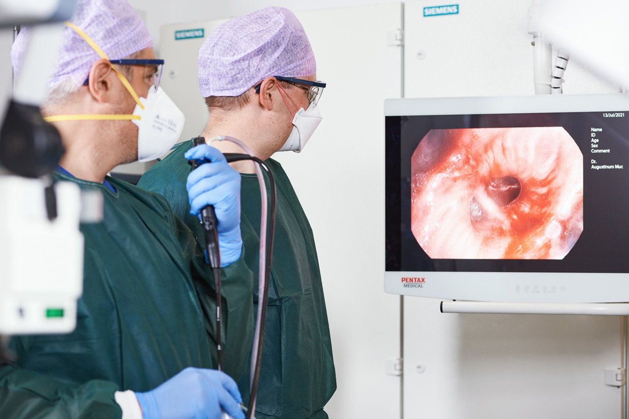 Zwei Ärzte sehen während einer Bronchoskopie auf einen Bildschirm, der die Bronchien zeigt.