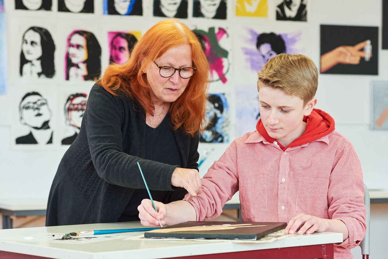 Eine Lehrerin der Samuel-Heinicke-Realschule gibt einem Schüler Tipps im Kunstunterricht
