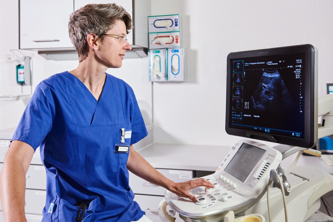 Eine Ärztin seht während einer Sonographie auf den Monitor des Ultraschallgerätes.