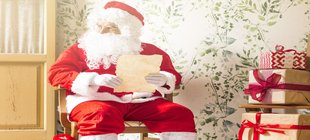 älterer Mann, Nikolaus-Kostüm das mit Wunschliste sitzt