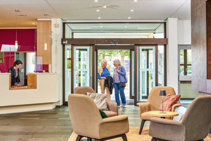 Zwei Seniorinnen unterhalten sich im Empfangsbereich des Augustinum Roth