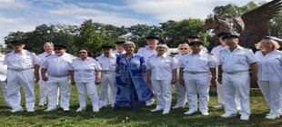 Weiß gekleidete Menschen und eine Frau in blauem Kleid