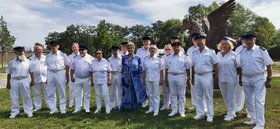 Weiß gekleidete Menschen und eine Frau in blauem Kleid