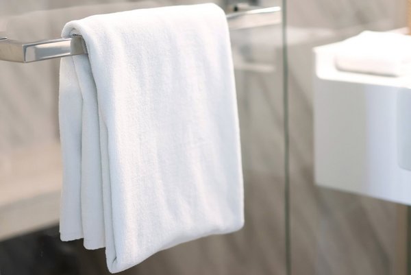 Nahaufnahme eines weißen Handtuchs, das in einem Badezimmer über einen Bügel hängt