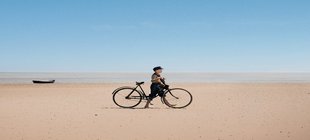Junge mit Fahrrad am Strand 