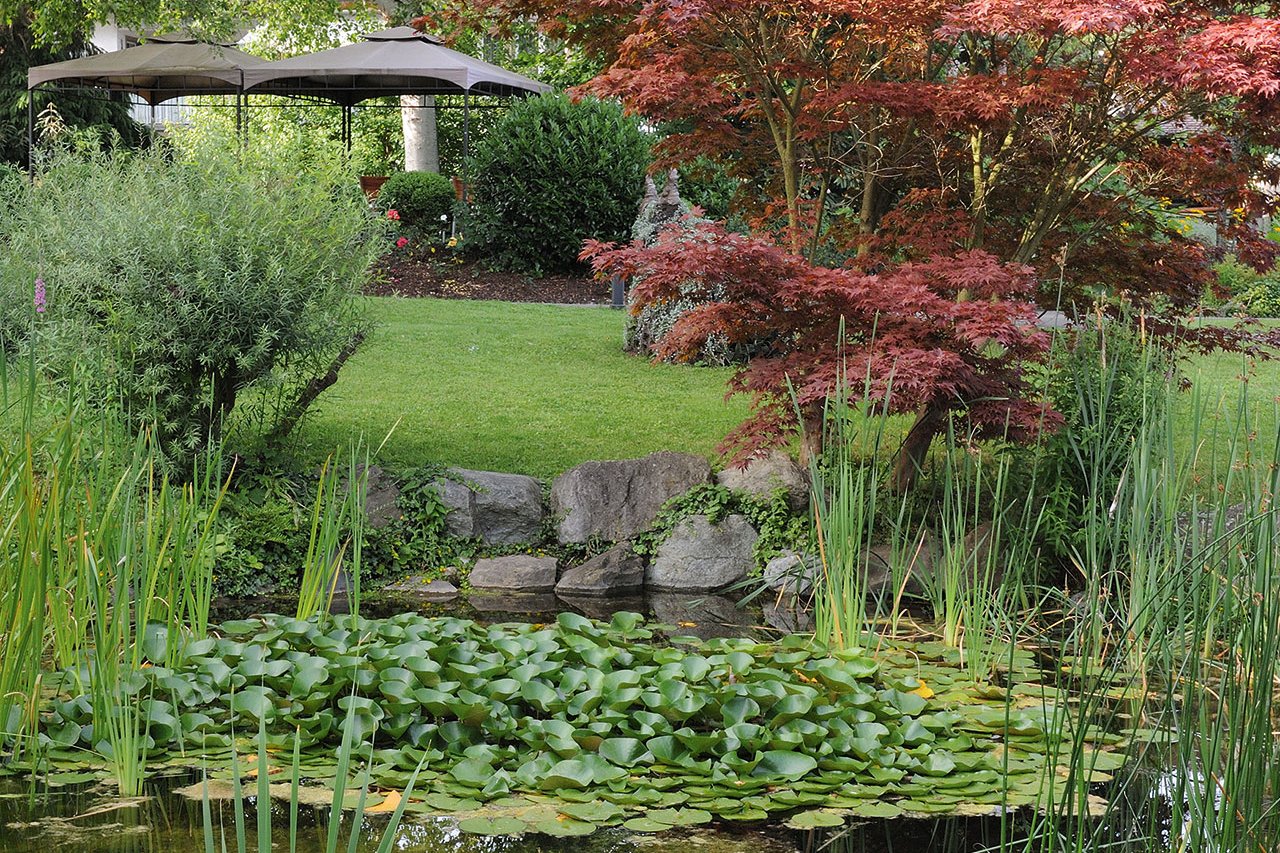 Lädt zum Spazierengehen genauso ein wie zum Entspannen: Der große Garten mit Teich und Pavillon. 