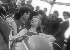 zwei junge Frauen sitzen im Waggon einer Achterbahn der 1950er