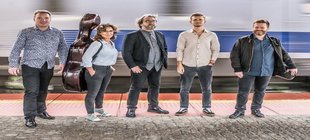Fünf Musiker mit einem Cellokoffer und einem Violinenkoffer