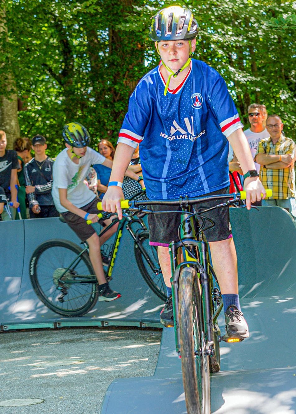 zwei Jungen mit auf Mountainbikes auf einem Pumptrack im Park des Landschulheim Elkofen