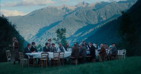 Mittagessenstafel mit Menschen vor Alpenkulisse