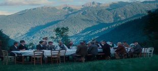 Mittagessenstafel mit Menschen vor Alpenkulisse