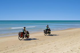 zwei Radfahrer am Strand