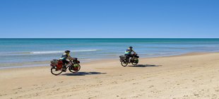 zwei Radfahrer am Strand
