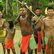 Kinder und Jugendliche eines Indianervolks aus Amazonien mit traditioneller Kleidung und bemalten Oberkörpern und Gesichtern stehen draußen.