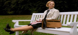 Junge Frau sitzt lächelnd auf Bank