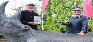 Zwei Männer hinter Bronze-Nashorn Zwei Männer hinter Bronze-Nashorn