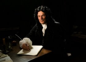 Gottfried Wilhelm Leibniz sitzt am Schreibtisch