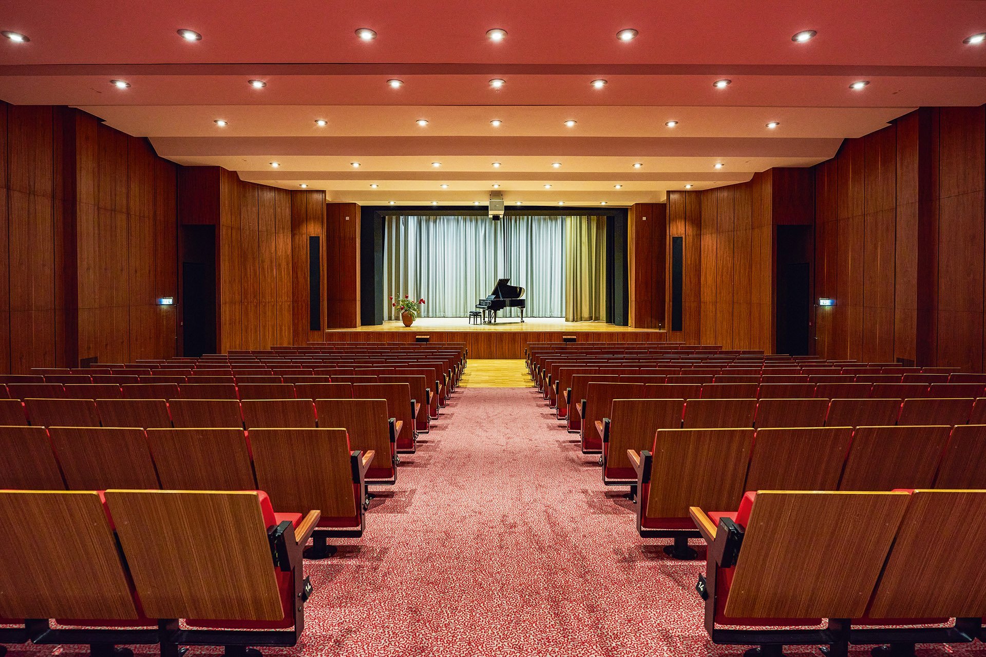 Augustinum Seniorenresidenz Bonn Theatersaal Die Sitze in einem Theatersaal mit Blick auf die Bühne, auf der ein Flügel steht