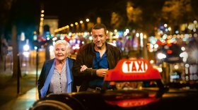 Alte Dame und junger Mann im nächtlichen Paris gehen zu einem Taxi